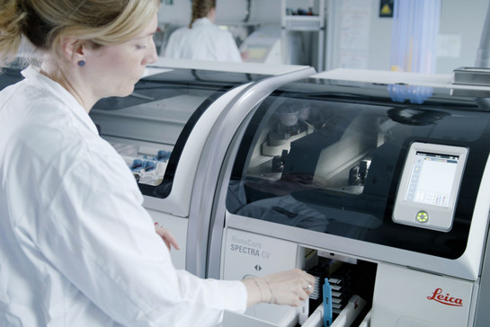 Eine Frau im Labor tippt auf einer Maschine