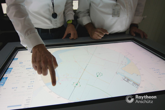 Zwei Männer zeigen auf eine digitale Landkarte